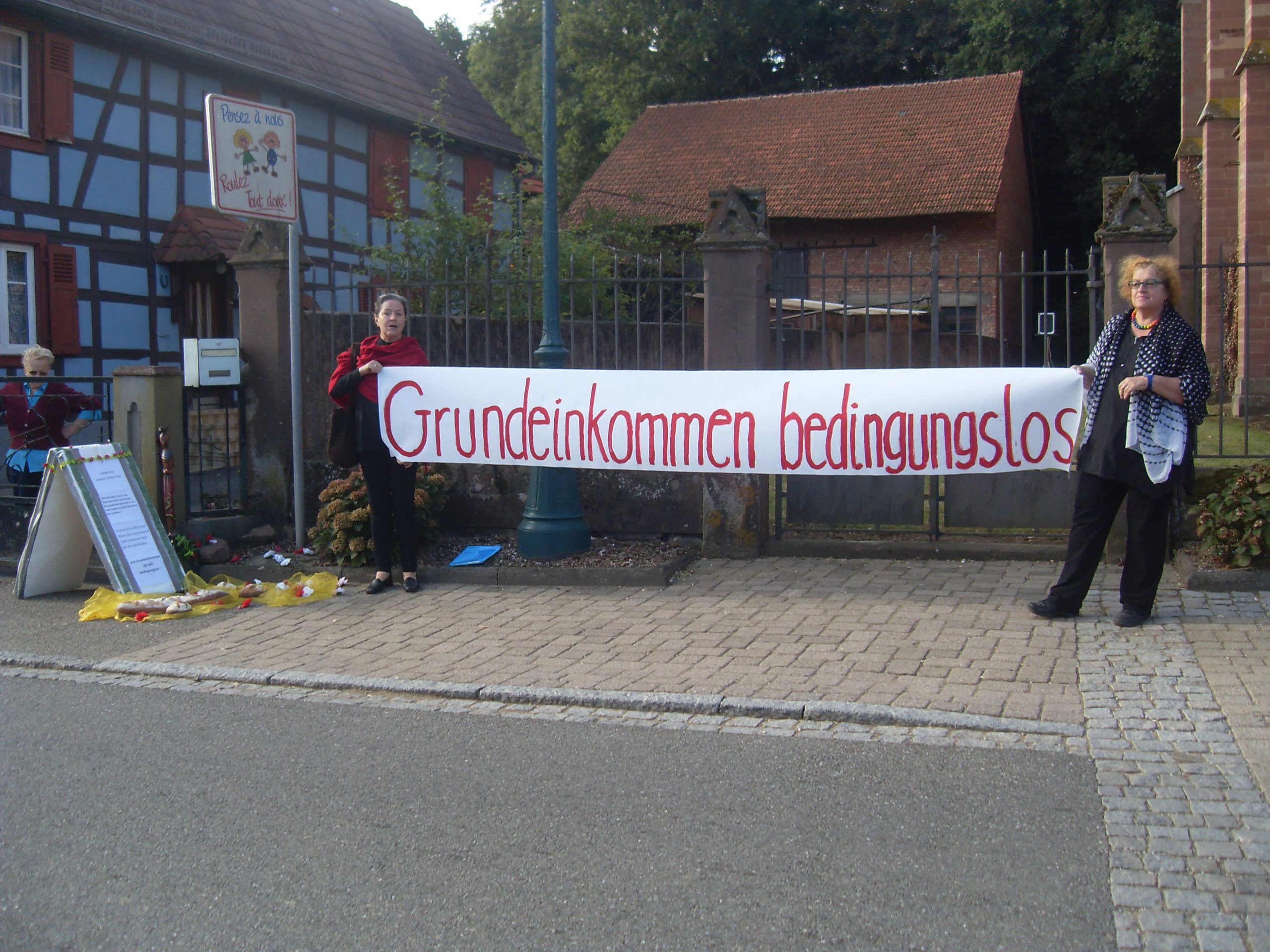 Zwei Frauen mit Banner: Grundeinkommen bedingungslos